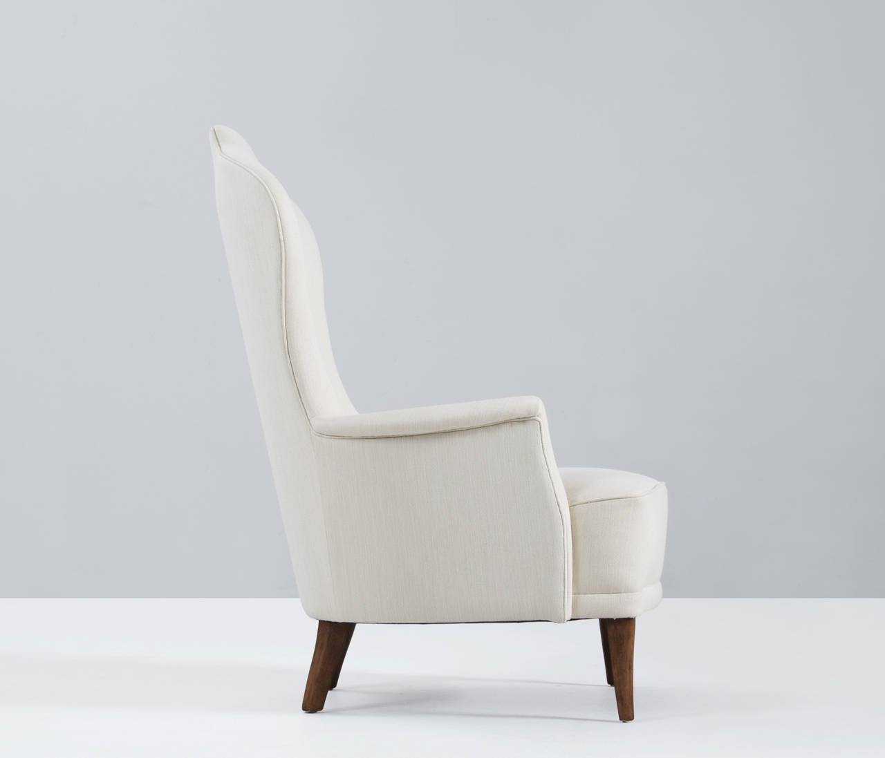 'Farmor' lounge chair, in fabric and wood by Carl Malmsten for O.H Sjögren, Sweden, 1960s. 

The unique lines and curves of the design are striking and the tapered wooden legs complement its shape beautifully, but it's experienced by us to be