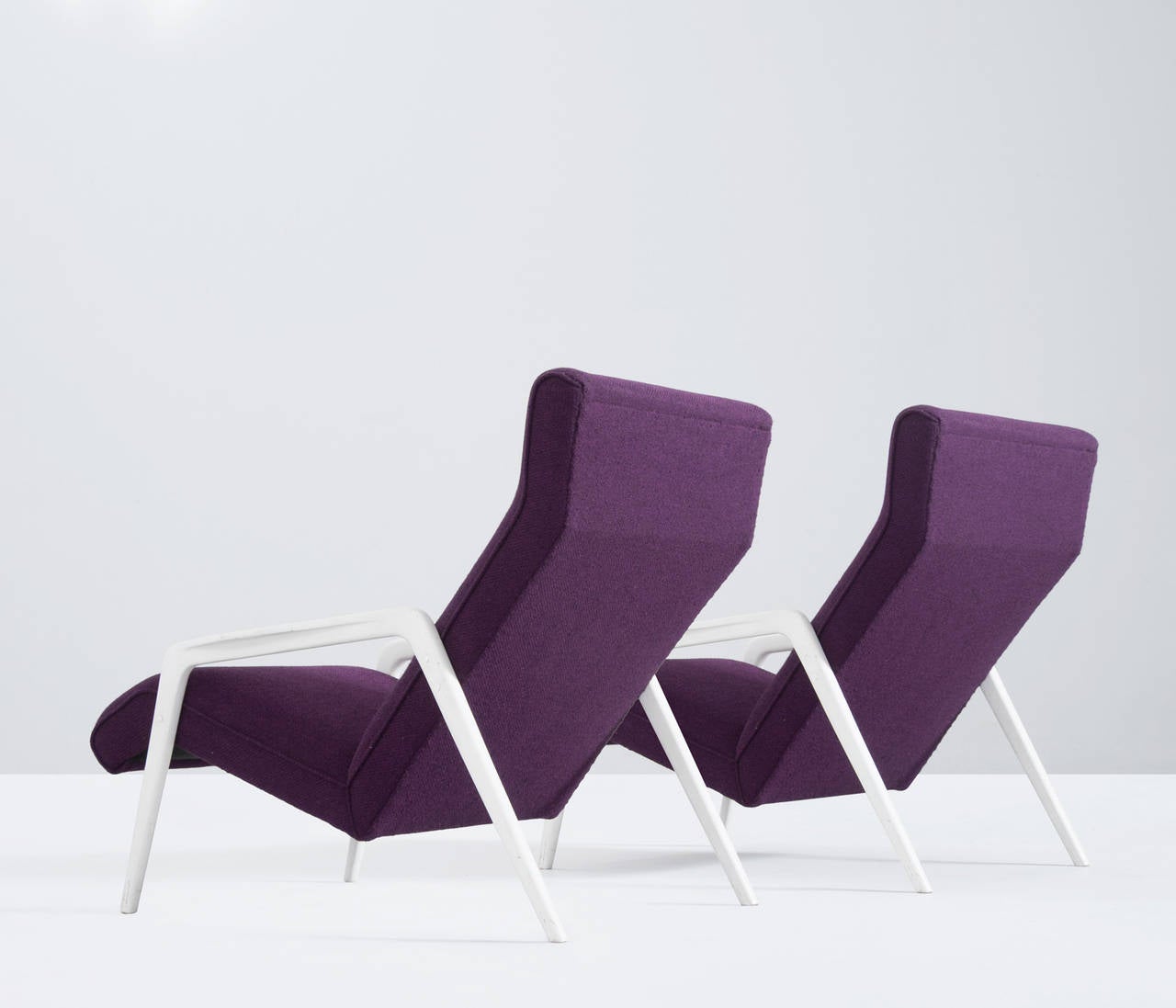 Set of two Italian lounge chairs.

The organic shaped line of the frames embraces the seating and creates a nearly floating expression. The wooden frames are white painted which gives the seating elements their strong appearance.

The armchairs