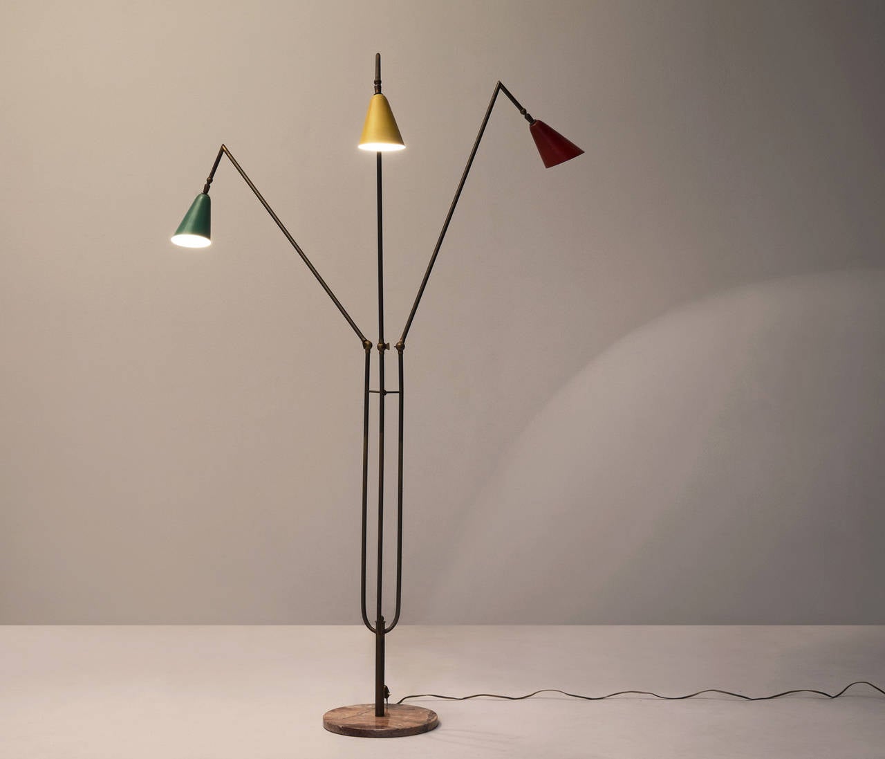 Italian floor lamp with colored shades, 1950s.

The three metal shades painted in yellow, green and red are adjustable to almost every position. The brass arms and joints together with the round marble base provides a highly decorative