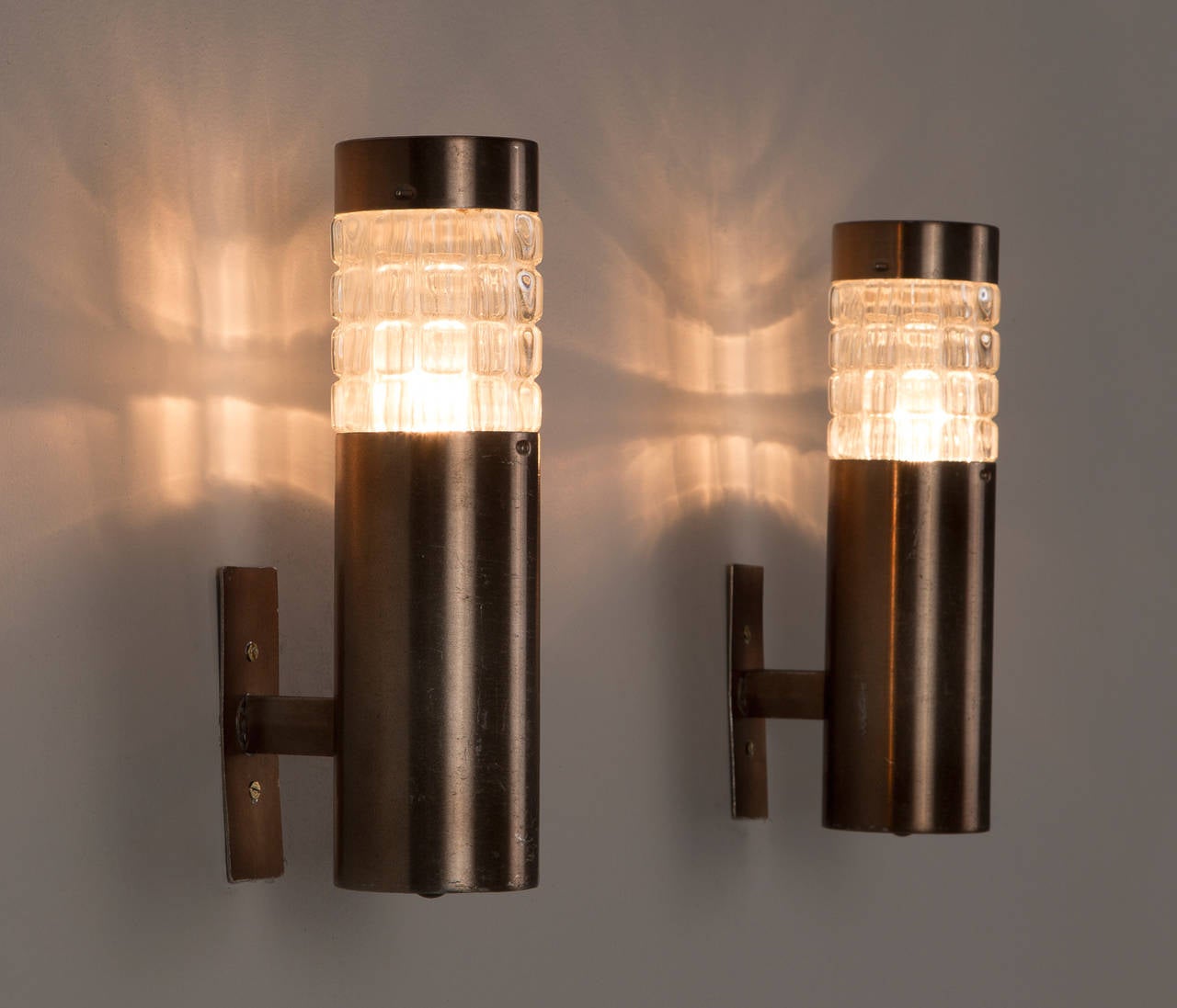 Set of four tubular sconces with structured glass in the manner of Studio BBPR.

Please note the price is per item.
