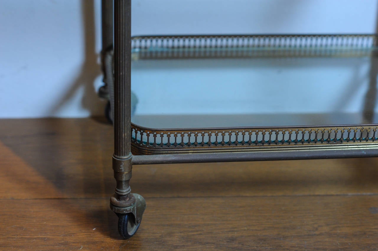 A set of three 1960s French brass nesting tables on wheels with glass tops 7