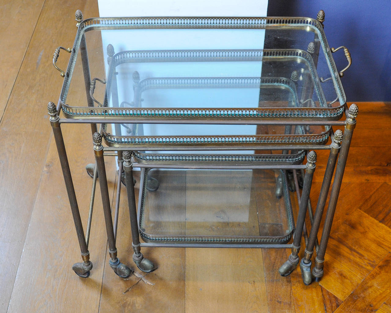 Mid-20th Century A set of three 1960s French brass nesting tables on wheels with glass tops