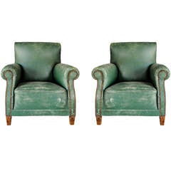 A pair of antique green leather club seats