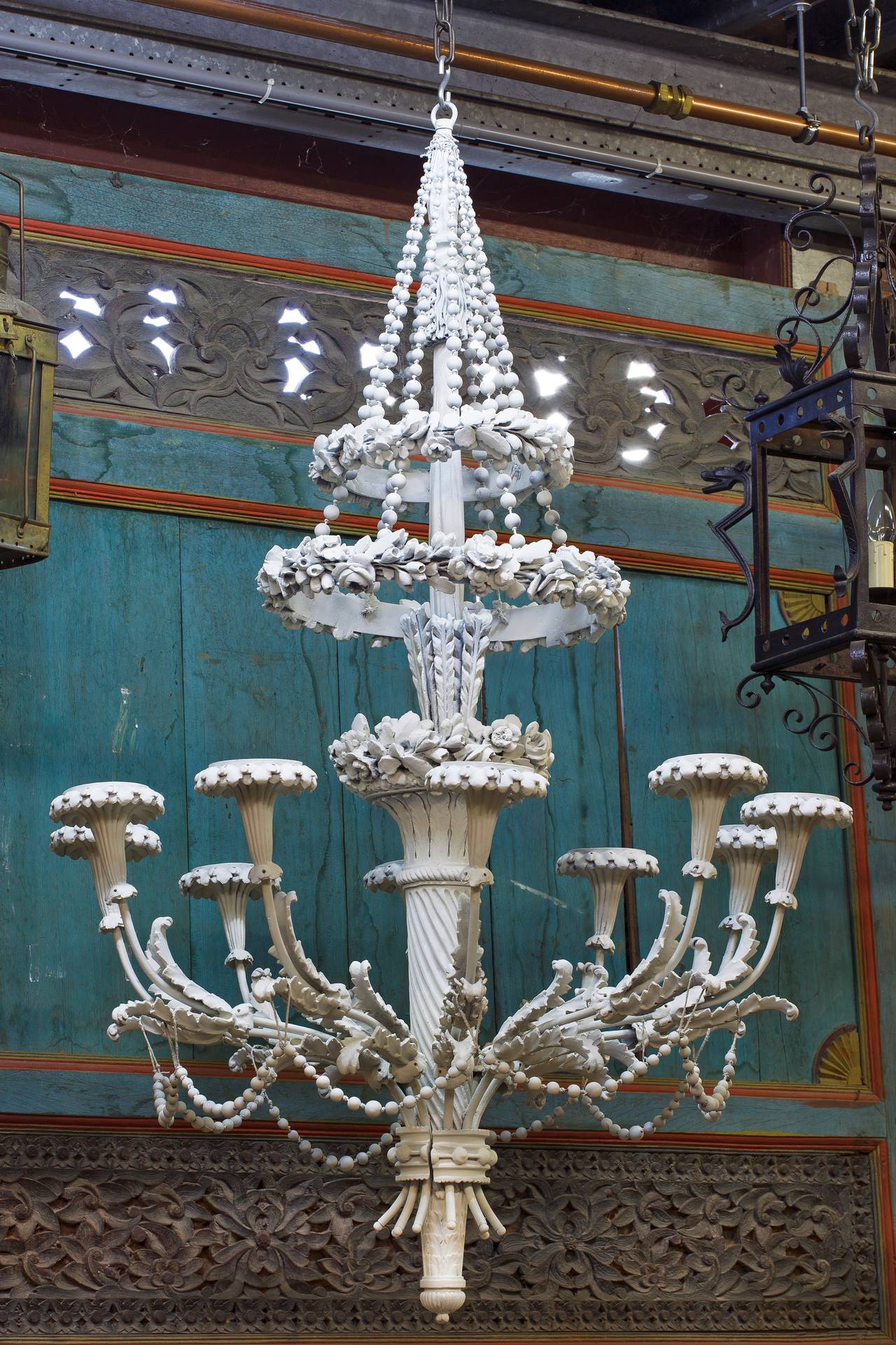 The sockets and drip pans on bead swagged arms rising from a flower adorned shaft, circa 1900.