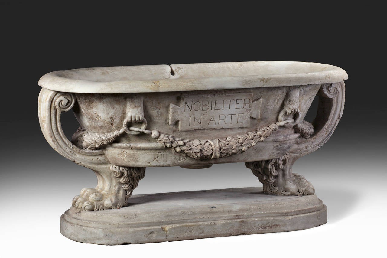 Planter of oval section, with everted rim, the long sides with laurel swags in high relief, the front with a tablet inscribed 'Magistri Romani,' with an openwork scrolling support at each end, above four paw feet, on an oval socle.