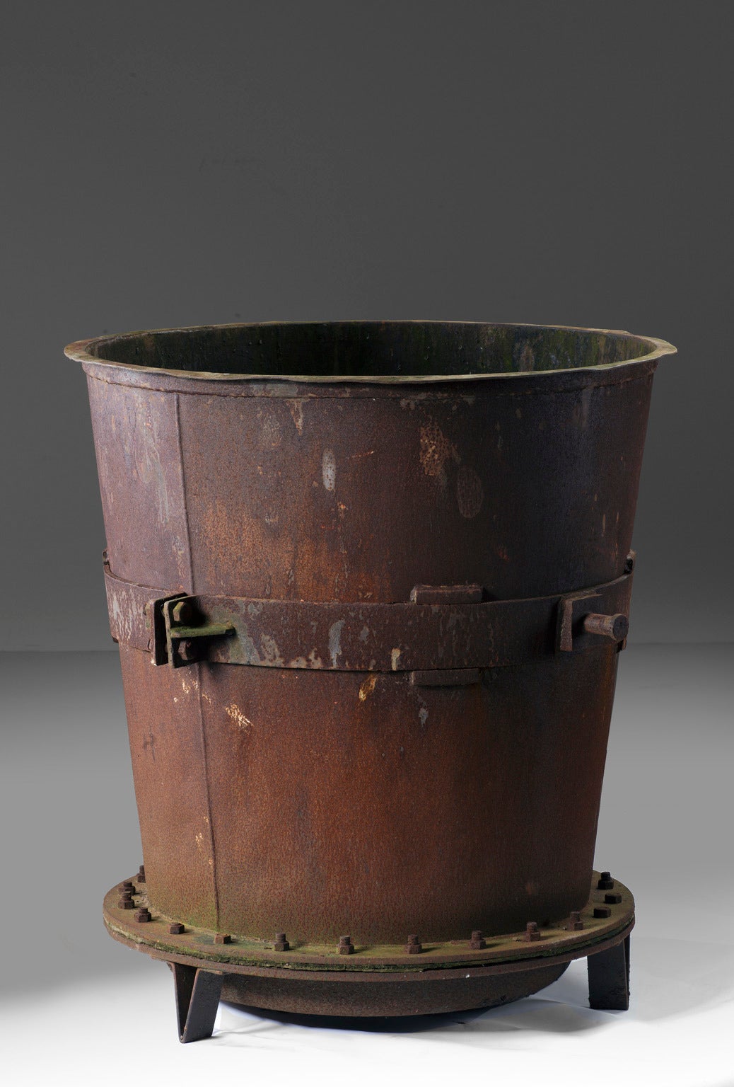 Late 19th-early 20th century, each of tapering cylindrical form, with bracket banding around the bodies, above circular riveted bases, each on three straight feet.