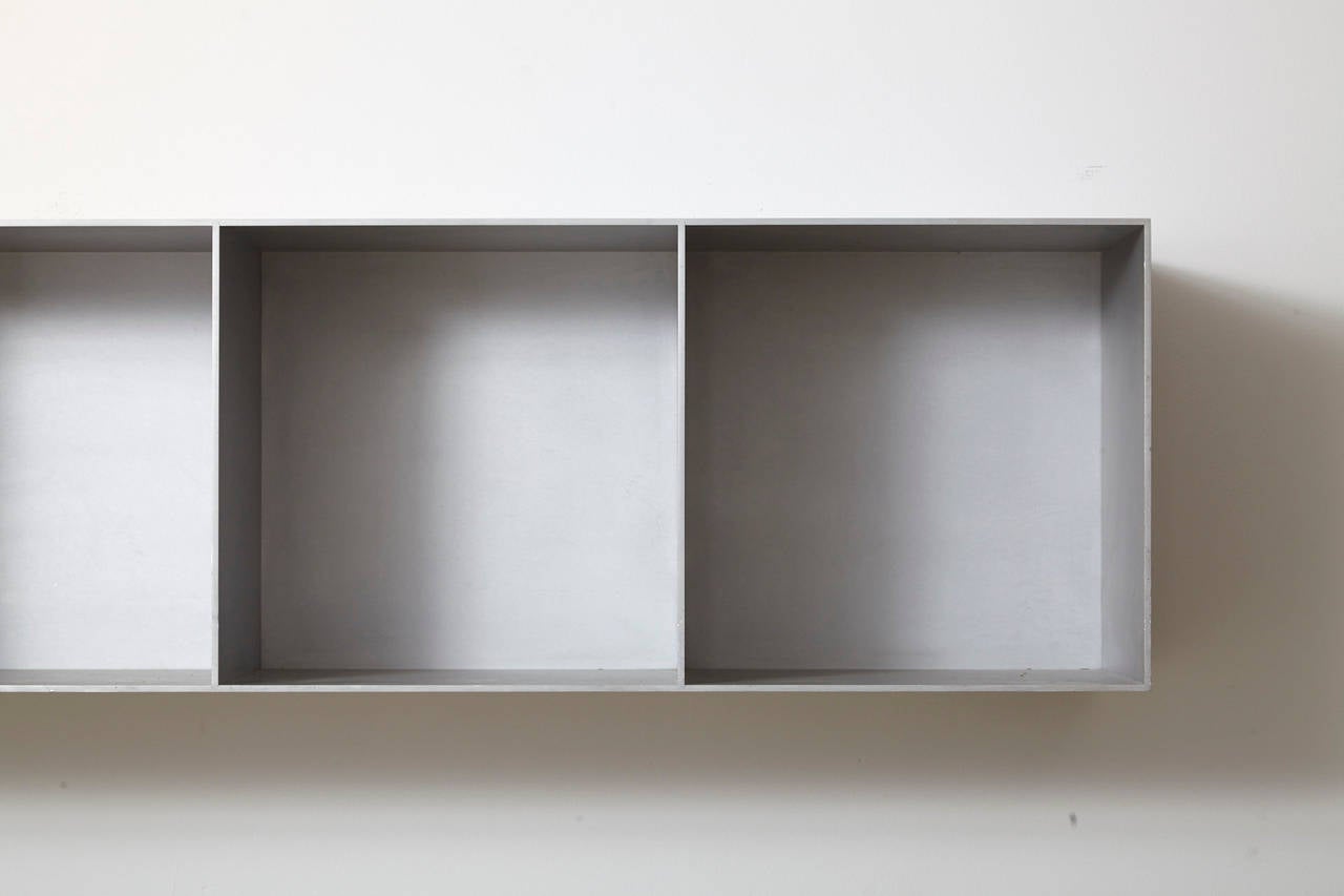 The cabinet K7V90 was designed by Maarten van Severen in 1990. The original design shows one reduced rectangular shape, divided in seven identical open squares. The architecture of the recurrent frame, produced in sanded aluminium, is stripped to