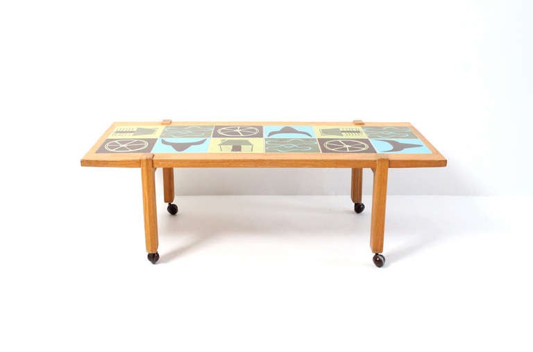 1950s  ceramic tile top table by A. Brandt Ranch Oak.  Table features 12 modernist Western themed tiles inset in a cerused oak table frame on 4 castors.  A. Brand Ranch Oak was made in Forth Worth, Texas from the 30's-70s. This example of from the