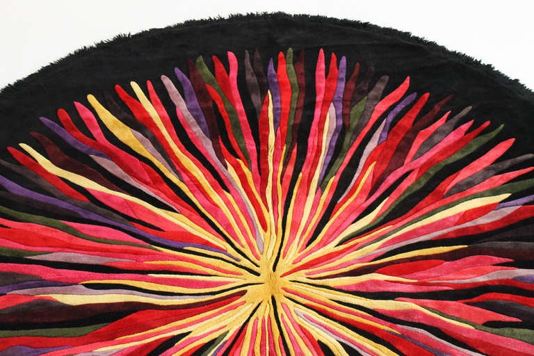 Large graphic and colorful circular rug produced by V'Soske in the 1960s.  Measuring almost 13' feet in diameter, this rug features 14 or 13 differently colors, a slight fringe, and 3D pile.  Rug was professionally hand cleaned in the past month. 