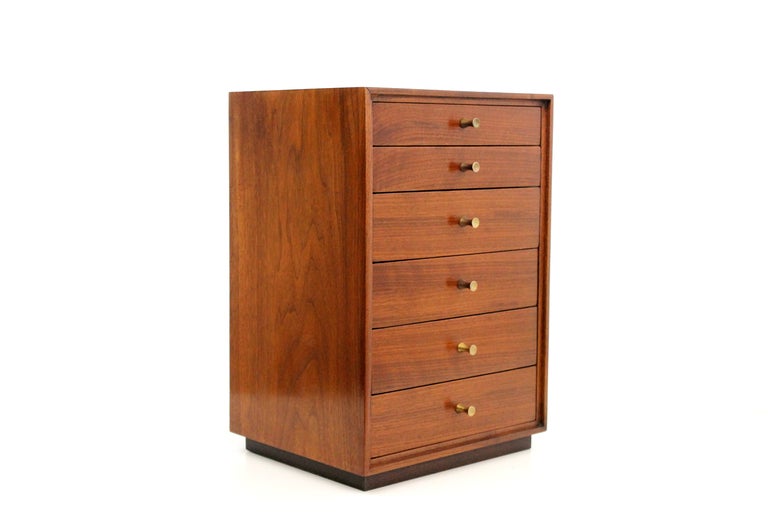 Mid Century walnut jewelry chest featuring graduated drawers and sculptural brass hardware.