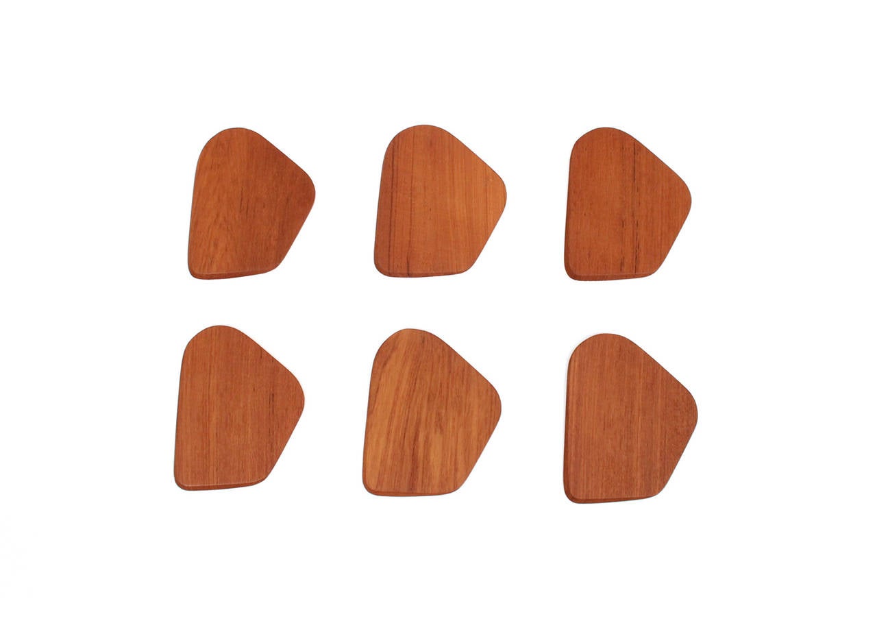 Set of six Danish made teak appetizer plates. Refined geometric design with subtle edge details. Perfect for small courses or cheese, as geta for sushi, or as large coasters for coffee and tea. Signed with an impressed mark to underside.
