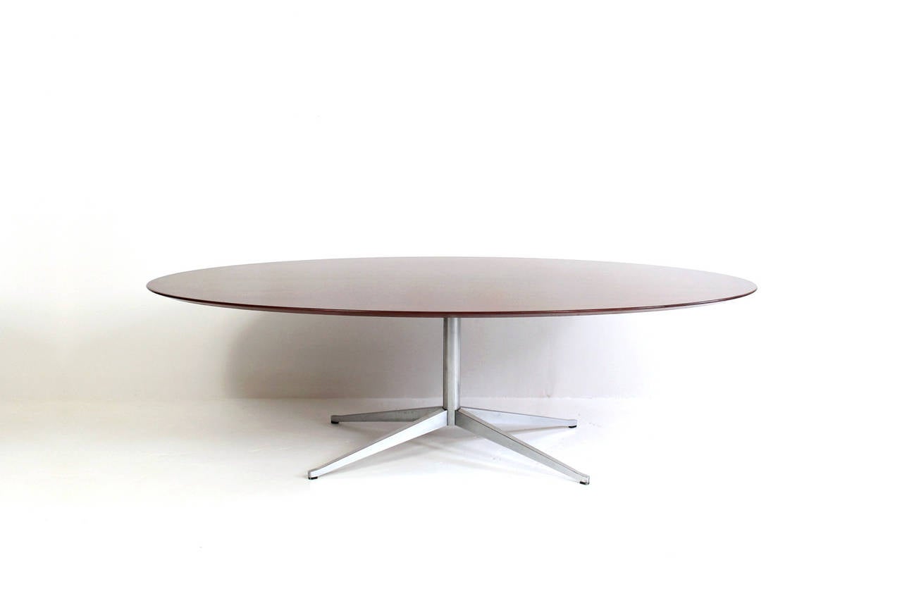 Largest size oval rosewood table by Florence Knoll for Knoll International. Table features a beautifully grained rosewood top, beveled edge, and chrome steel pedestal base. Iconic design by one of the great American designers.