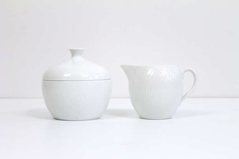 Creamer and covered sugar in carved porcelain by Axel Salto for Royal Copenhagen.  Each piece is signed with the Royal Copenhagen and Salto marks and features a strong geometric decoration.  Understated and elegant pairing for your breakfast table.