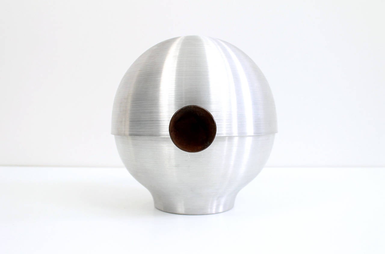 Early modernist spun aluminum vessel with tilting lid designed by Russel Wright for Metware. Originally marketed as a combination bun warmer, ice bucket, and fruit bowl. Strong machine age styling to this utilitarian object. Knobs of heat resistant