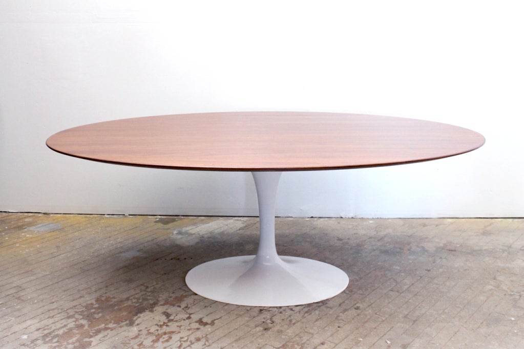 Oval walnut dining table by Eero Saarinen for Knoll International.
