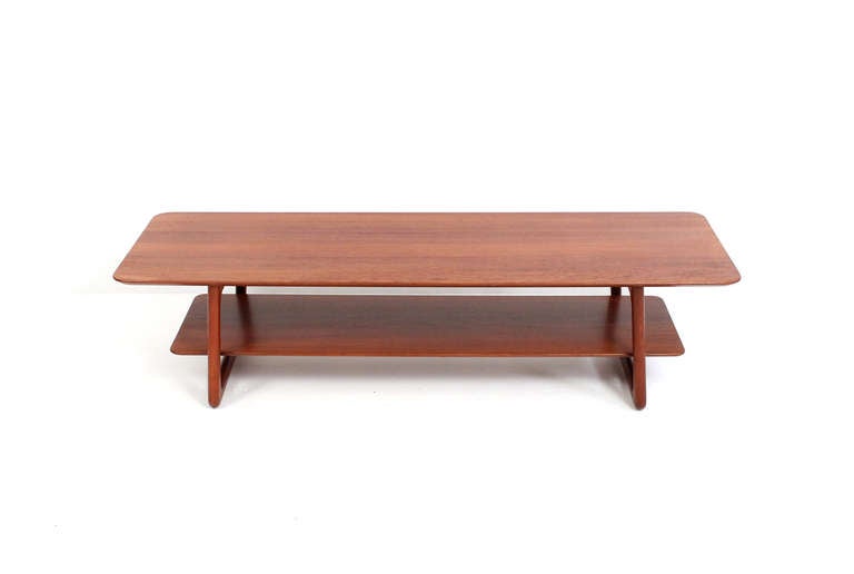 Teak coffee table designed in 1955 by Hvidt & Molgaard for France & Daverkosen.  Sculptural and built entirely of solid teak with brass connection details.  Bottom shelf is removable and has potential use as large serving tray.  Rare and seldom seen