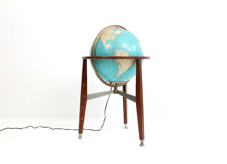 Freestanding illuminated glass globe with walnut frame designed by Edward Wormley for Dunbar.  This is the less commonly seen globe design.  Quality details include a glass globe, metal feet and stretcher and brass connections in all three legs.