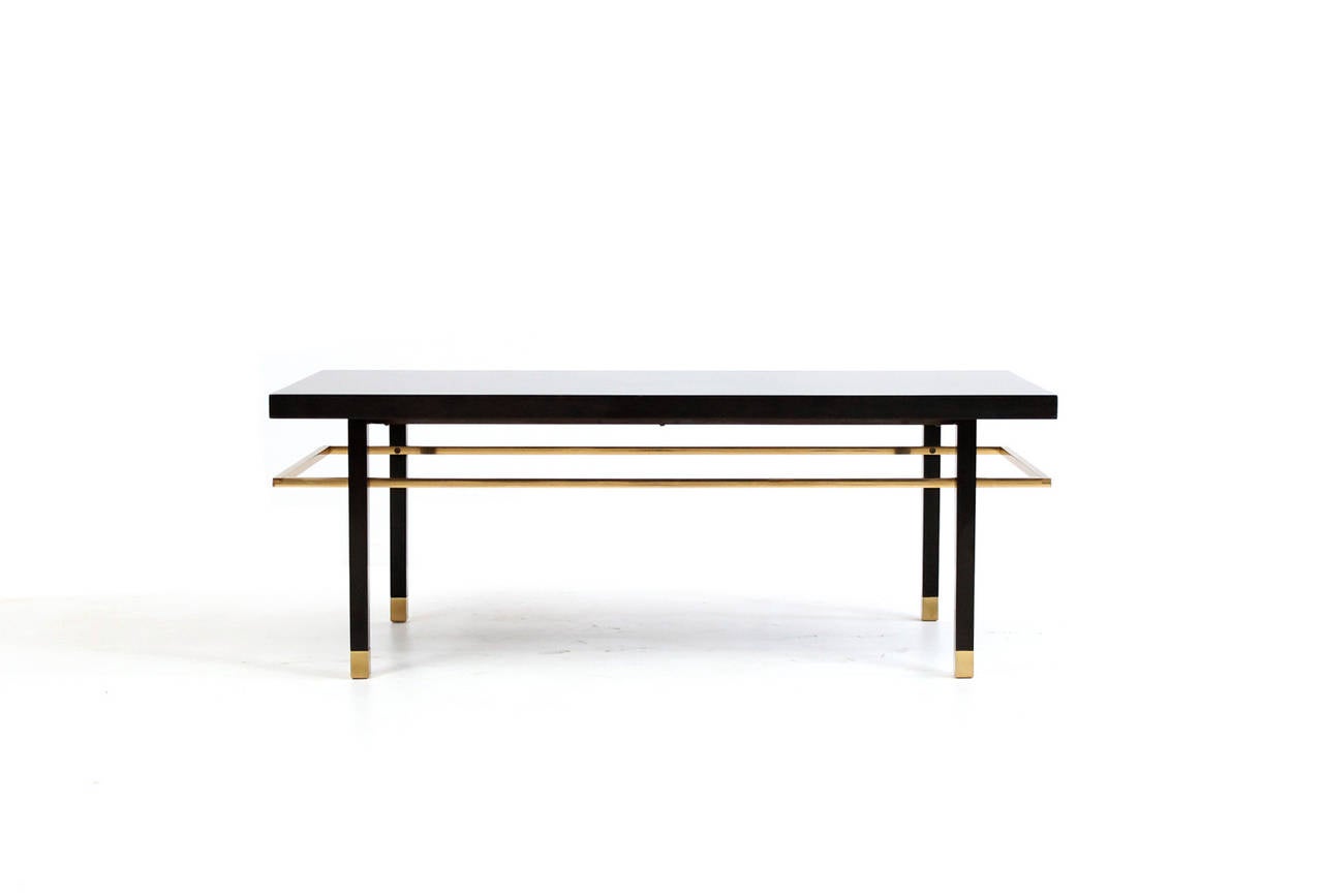 Elegant bench or table by American designer Harvey Probber. Constructed of mahogany with floating brass stretcher, brass sabots, and a loose upholstered cushion. Bench has recessed steel supports and is extremely sturdy and well built.