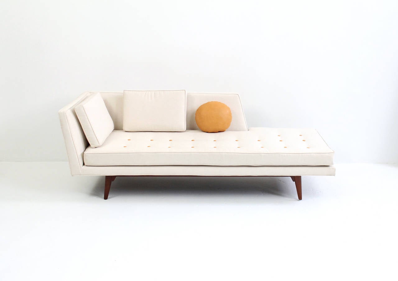 Elegant and modern single arm chaise longue by Edward Wormley for Dunbar. This sofa is part of a sectional seating group and can Stand alone or be combined with the other piece offered here. Elegantly upholstered in linen with leather button details
