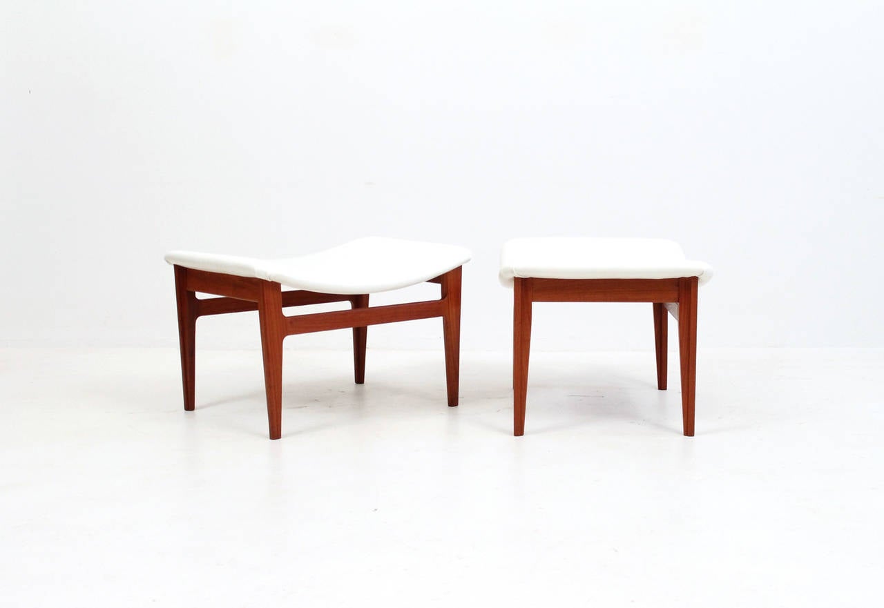 Pair of teak and leather ottomans or stools by Danish designer Finn Juhl for France and Sons.