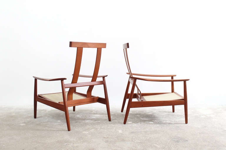 Pair of sculptural high back teak lounge chairs by Danish designer Arne Vodder for France and Sons. These chairs feature an ingenious system which allows them to recline in three positions. Both chairs are marked with a France and Sons decal and