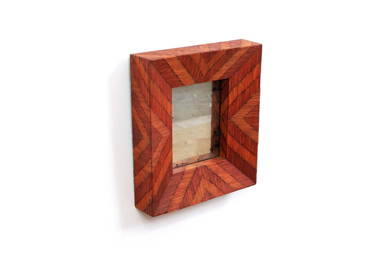 1930s Folk Art matchstick mirror. Features geometric patterning, attractive tones of red and orange and a deep angled profile. Original mercury mirror deeply patinated and cracking pleasingly in areas.