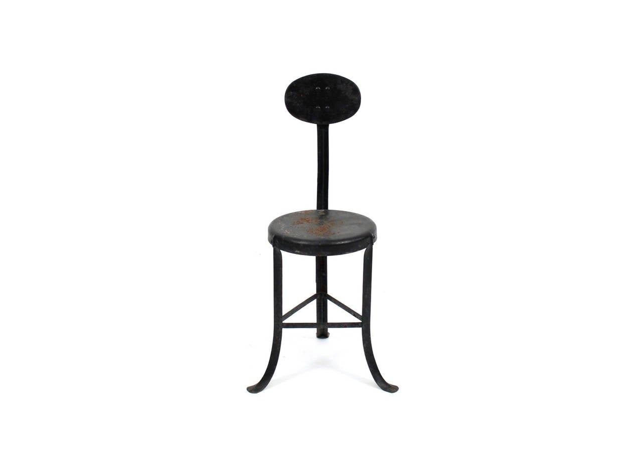 Graphic high back Industrial steel stool or chair from the early 1900s. Pleasing original patina to enameled metal surfaces.