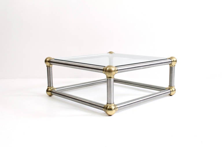 Masculine and well-built coffee table in steel, brass, and glass. Design of table resembles interconnected molecules or decorative iron work. This very chic table dates to the 1960s.