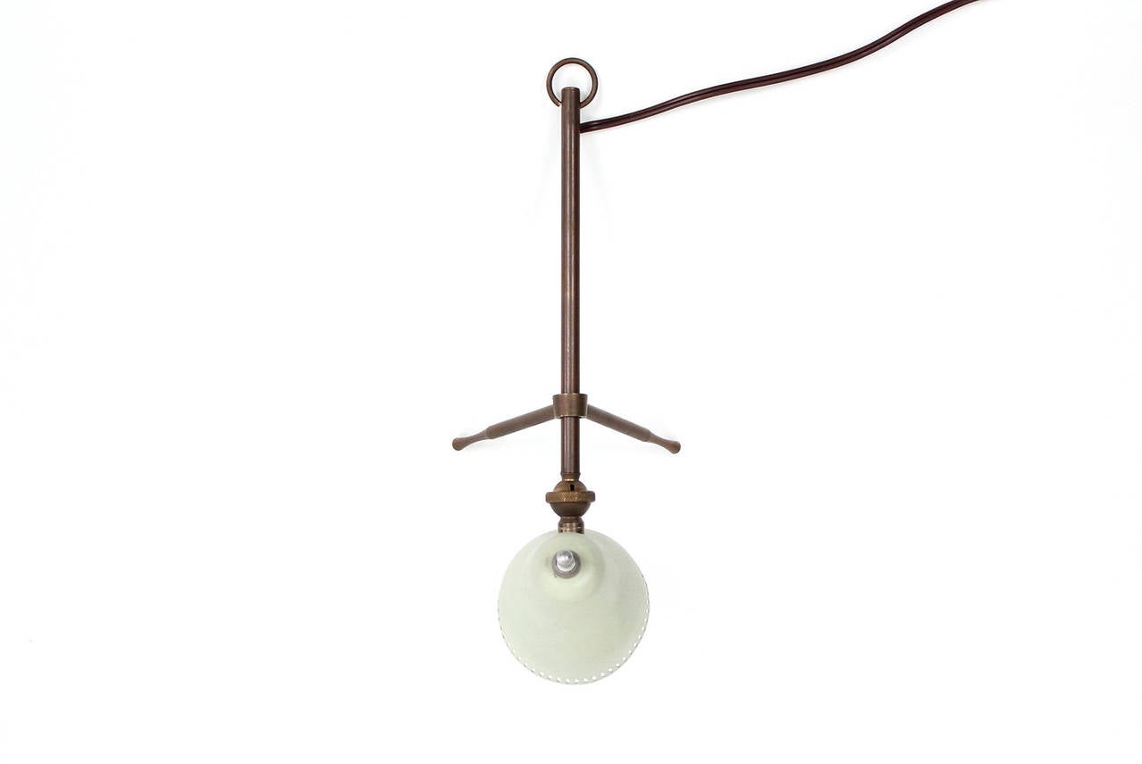 Table lamp by Italian designer Giuseppe Ostuni for O-Luce. Legs and shade allow for adjustment of height and direction of light. Lamp is designed to hang on the wall when not in use.
