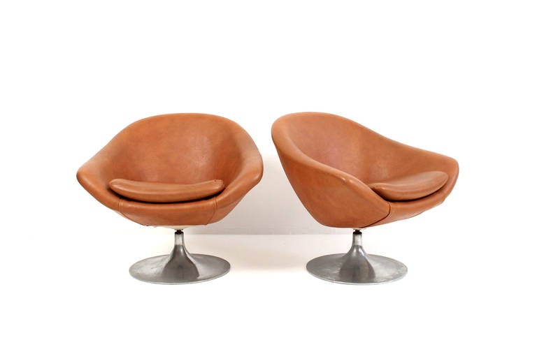 Pair of Swedish designed pod chairs by Overman. These swiveling lounge chairs are upholstered in a natural looking Naugahyde with rare aluminum tulip bases. Comfortable lounge seating.