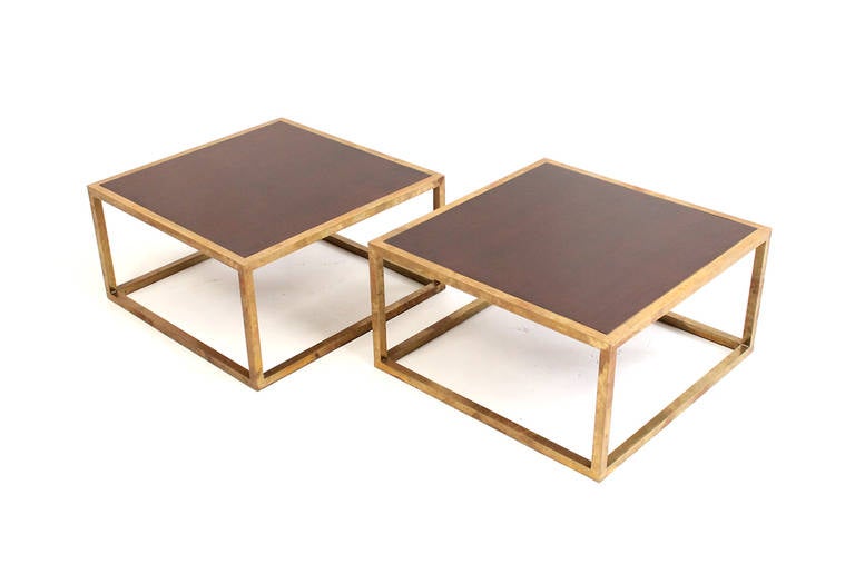 Stunning pair of square brass end tables with wooden tops.  Can be combined to function as a coffee table. Minimalist in their simple geometric design. Unpolished with a superb patina to the brass frames.