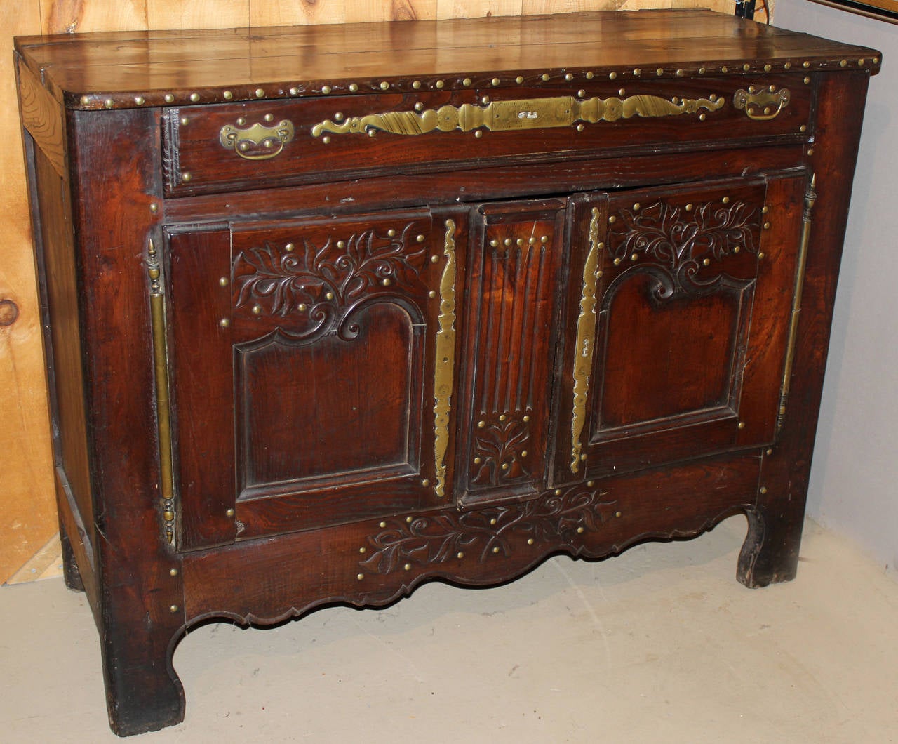 Exquisite 18th c. French buffet or server in darkly stained oak with wonderful carving and nice brass hardware. One single drawer over two doors, opening to one interior shelf. This piece is also available with a cupboard top if interested under a