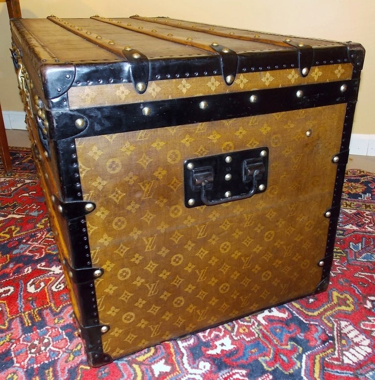 Louis Vuitton trunk circa 1895 with earliest woven monogram fabric, birch slats, zinc-lined bottom and wheels at the corners.  Complete with original interior trays, cross-ribbon lid and Louis Vuitton paper label.