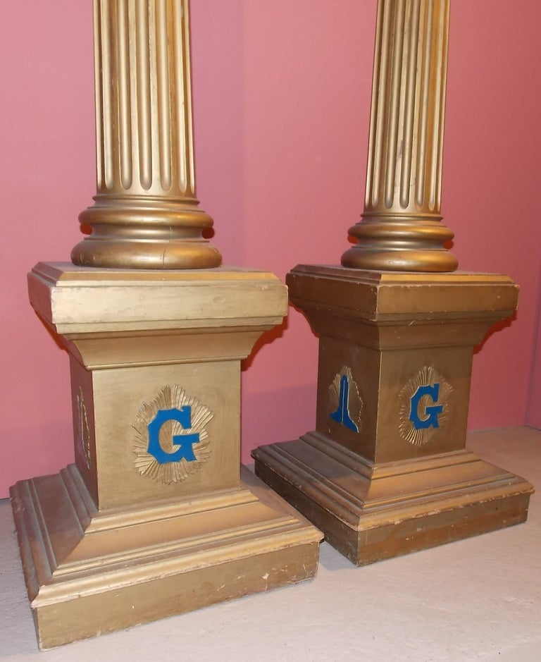 Pair of Masonic pedestal columns, American circa 1920. Globes surmounting a corinthian capital raised on a lettered plinth.