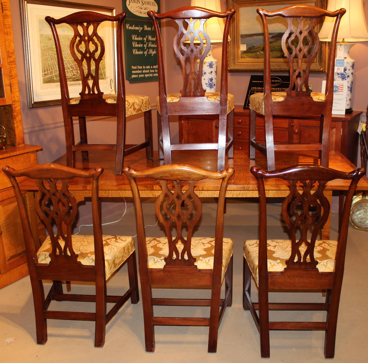 A beautiful set of six Chippendale style foliate carved mahogany dining chairs, recently appointed  in silk. The carved crest above a pierced splat above an over upholstered frame with fluted front square tapered legs.