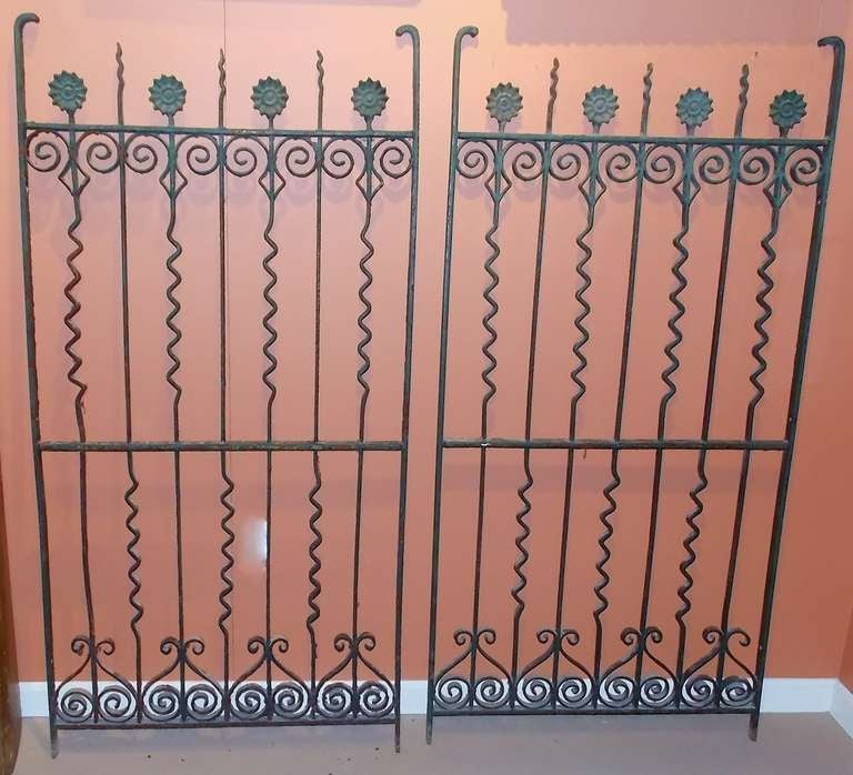 Pair of cast iron fence gates with and sunflower and fanciful scroll design. Great size and nice surface in old green paint.