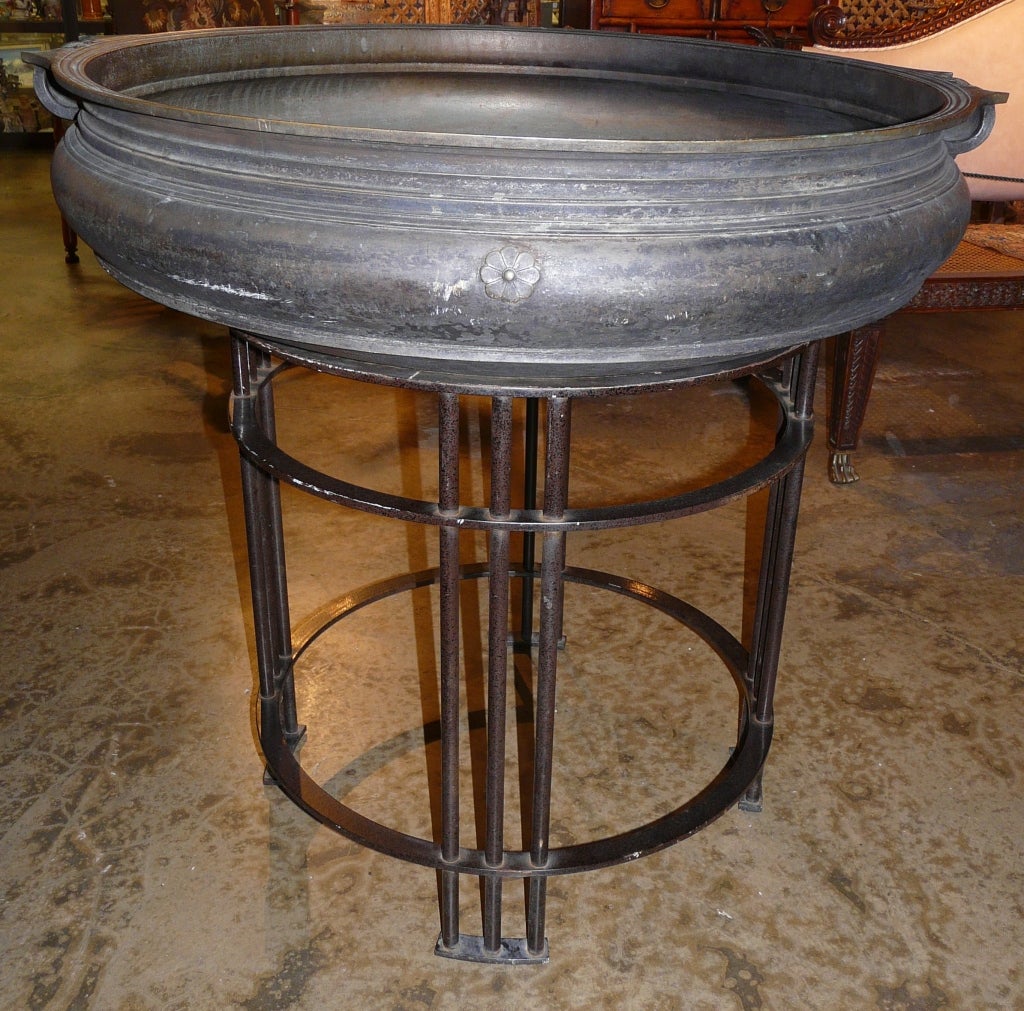 Fine bell metal or bronze cauldron or braiser with molded everted rim with opposing rolled handles on a later cast iron tubular stand.  19th century, Kerala, India. The shallow cauldron used in celebrating meals in Hindu temples, primarily in India.