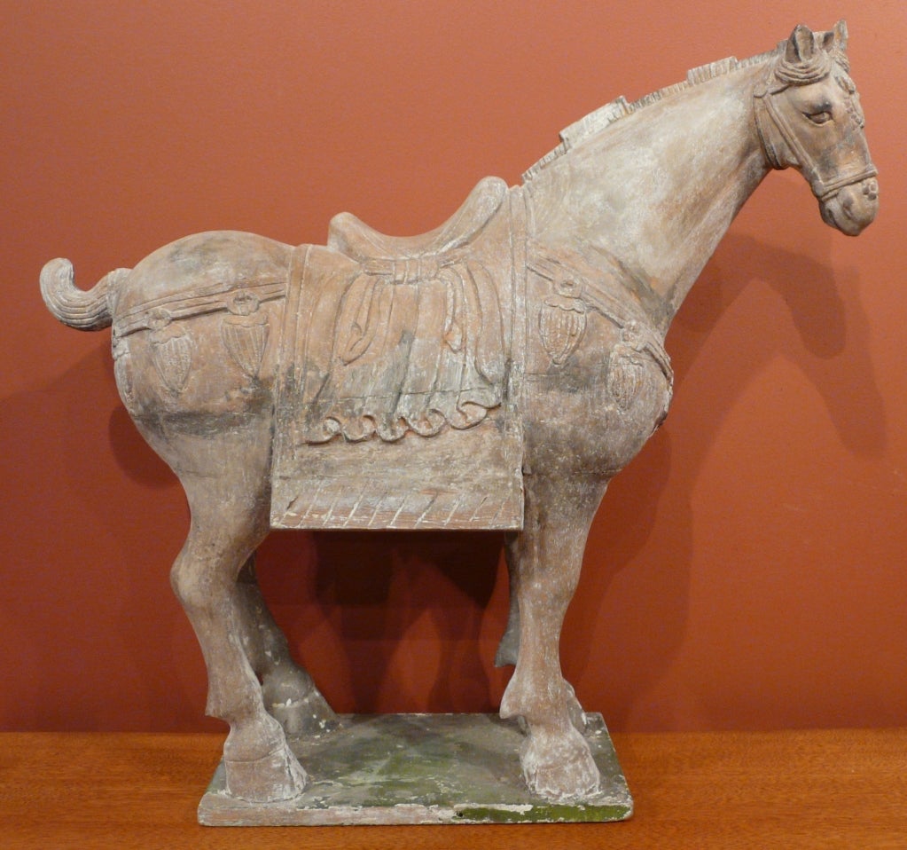 Carved and decorated Tang horse. Chinese, Tang Dynasty style, carved in Ming Dynasty. Nicely carved polychrome decorated figure in full trappings with head modeled slightly to the side, joined to flat plinth. Horse's mane carved in crenelated manner