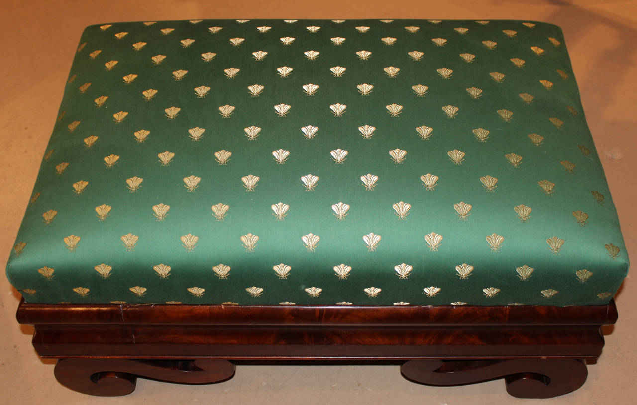 A large Boston Classical or Empire mahogany ottoman from the 19th century. Freshly appointed with silk upholstery. Mahogany veneers with 