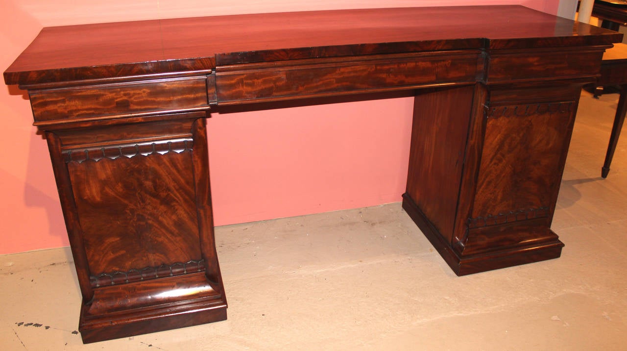 A spectacular mahogany and mahogany veneer Classical or Empire pedestal sideboard, attributed to Isaac Vose, Boston, fitted with one large central drawer flanked by two small drawers, over a pedestal door on each side. Each pedestal door opens to a