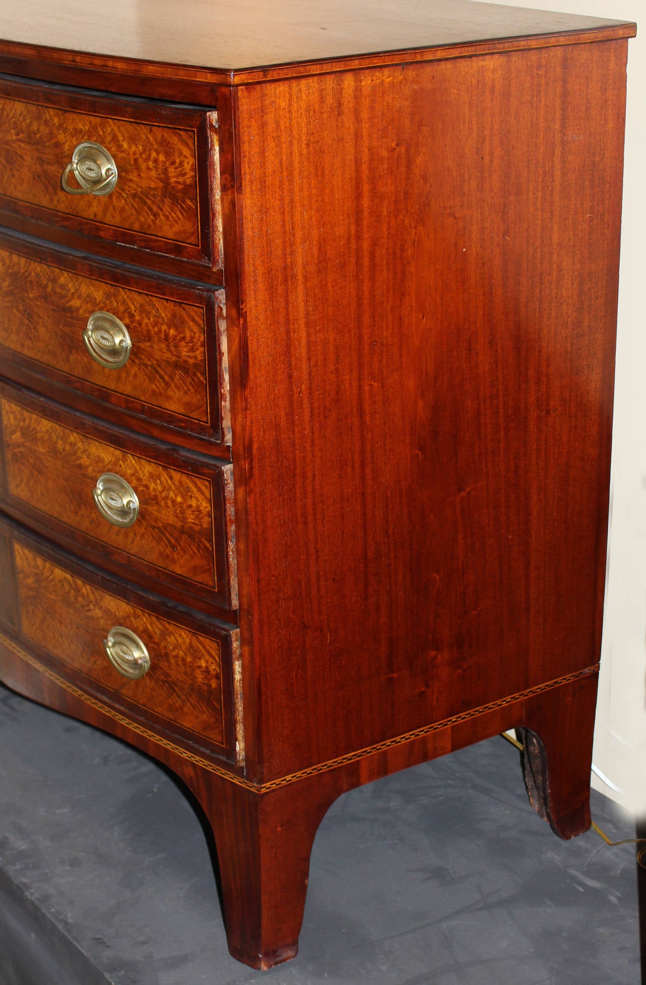 An exceptional late 18th century Federal mahogany bow front chest with wonderful oval and rectangular flame birch veneers, along with lovely satinwood checkered and line inlay, period brass pulls, and replaced escutcheons.Probably from Portsmouth,