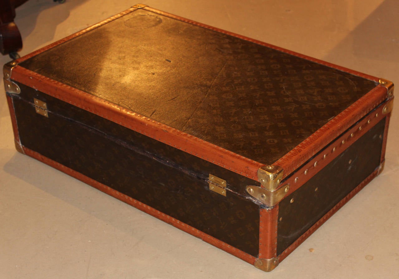 A Louis Vuitton hardside luggage suitcase with interior tray and original key, circa 1940’s, with interior gold label, monogrammed on front “C.P.W.”