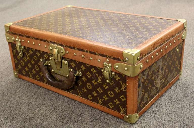 Louis Vuitton vintage hardside suitcase. Louis Vuitton monogrammed and embossed materials, leather trim and polished brasses. Largest suitcase made by Louis Vuitton. Serial number 768838.  Lock number 110812. Circa 1930's.