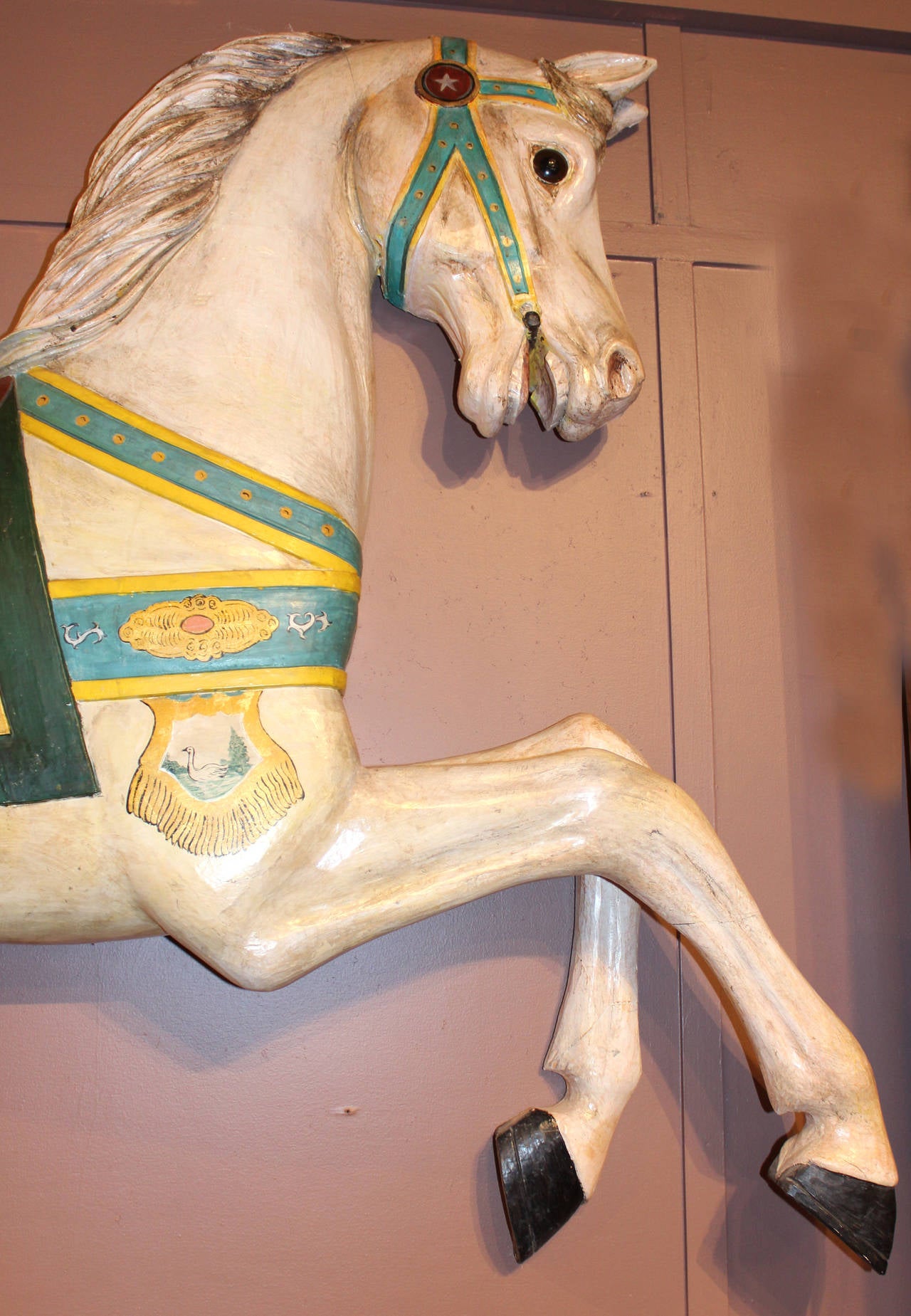 A large carved wooden polychrome paint decorated carousel prancer horse, probably used on a carousel center or bench end, with restoration to the head and legs. Probably early 20th century, recovered from a MA office building in the