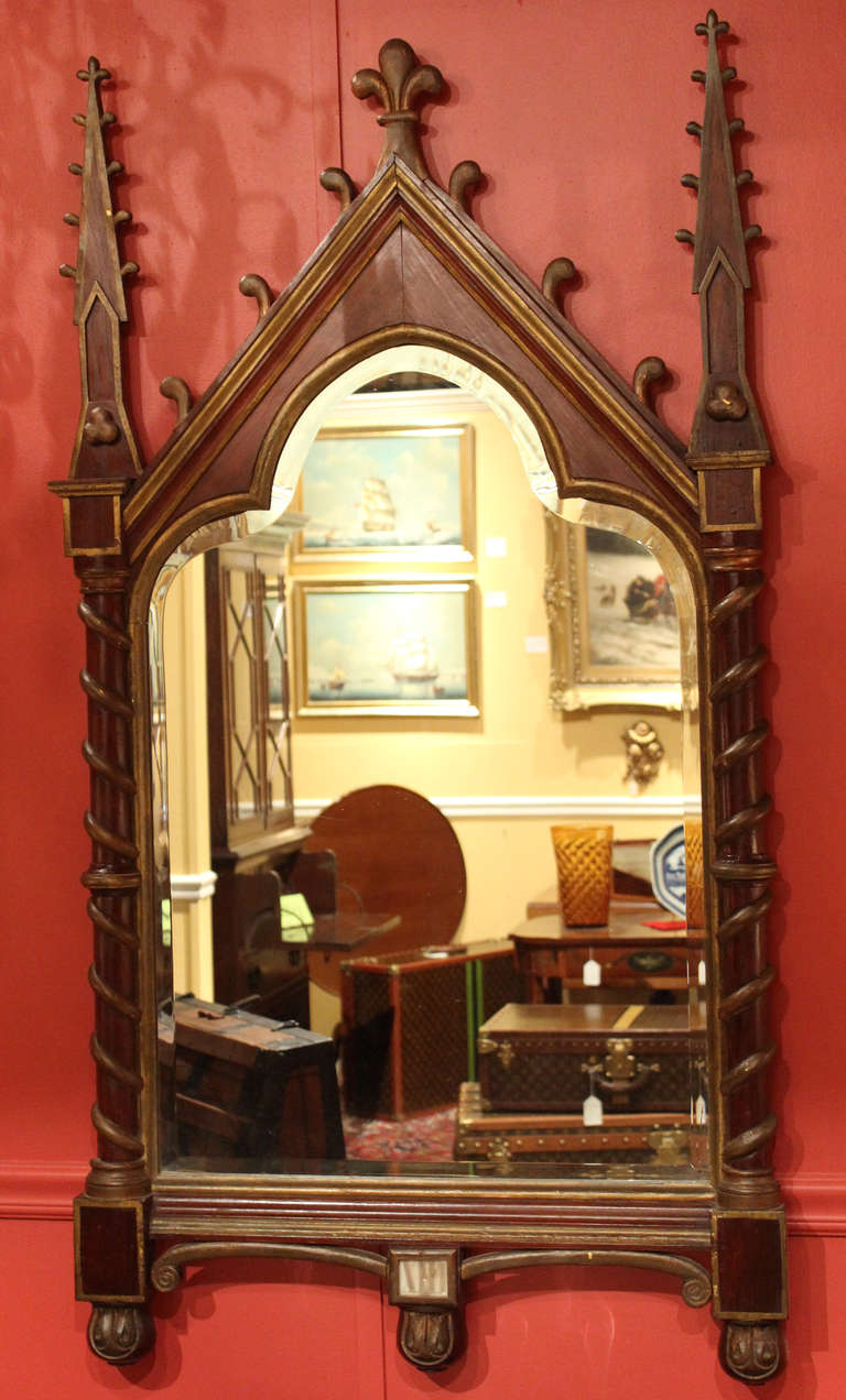 19th century Gothic Revival rosewood mirror, with spires surmounting each rope decorated column flanking the mirror plate. Gilt accents and shaped beveled glass mirror.