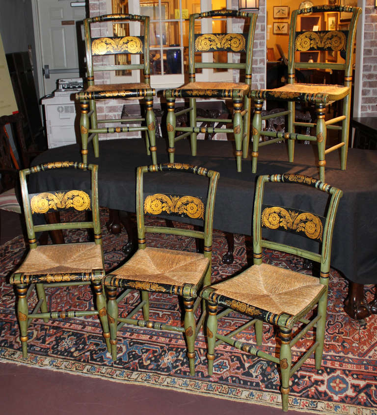 Set of Six 19th century fancy chairs in green and black, with gold foliate decoration, rush seats, each signed by Ruth Hicks.