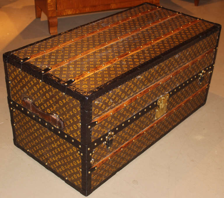 A fine example of a Louis Vuitton wardrobe trunk, circa 1920s, with monogram exterior, steel edging, beach wood slats, leather handles, brass and steel lock and latches, brass L.V. rivets, linen lined interior with six drawers, removable case, and