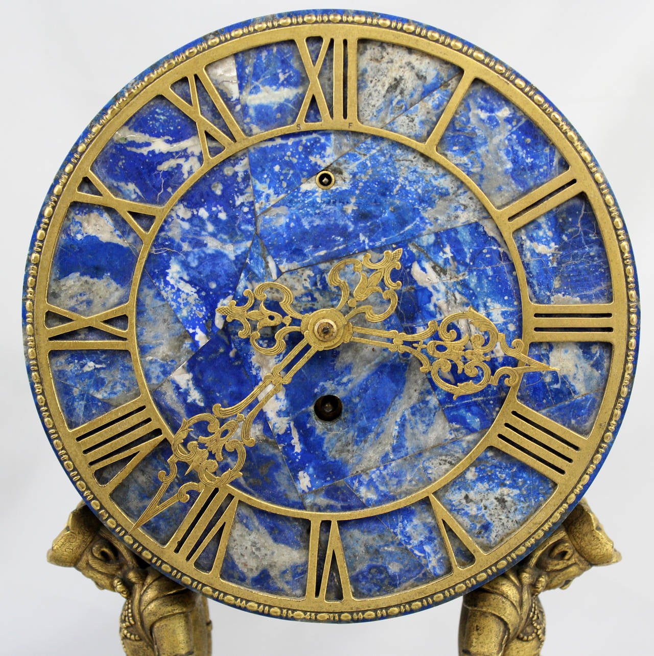 A spectacular Brazilian lapis lazuli mantel clock with doré bronze, dial applied with pierced hands and Roman chapters, supported by two sitting doré bronze Chinese figures, with rectangular lapis plinth, signed E.F. Caldwell & Co, New York.