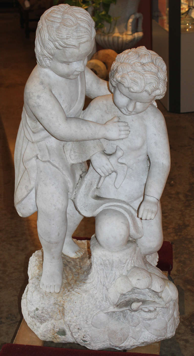 A fine example of a carved marble statue of two children playing with doves, unsigned, nice proportions and detail, with reattached hand on one child. Probably from the early to mid 20th century.