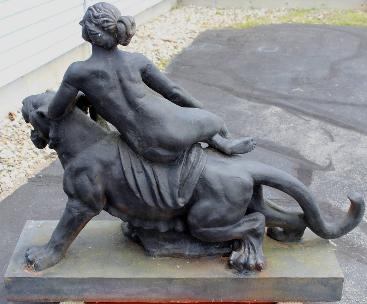 A spectacular 19th century cast iron sculpture of a classical nude woman on a lioness with drapery all supported by a rectangular plinth. Painted in black with a nice patina. A great outdoor garden element or centerpiece for your landscape decor.